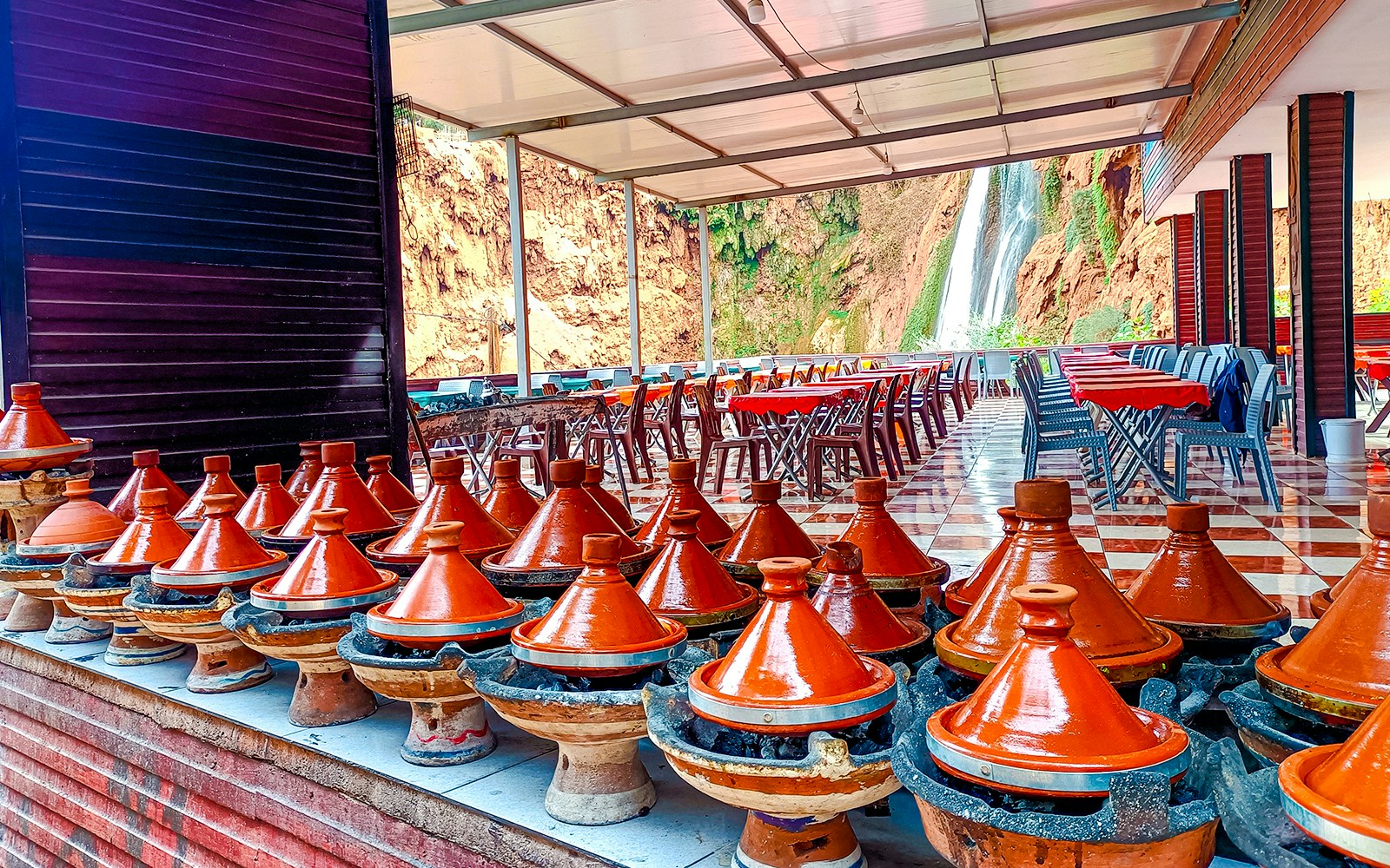 Traditional Moroccan tajines cooking in restaurant near Ouzoud Waterfalls.