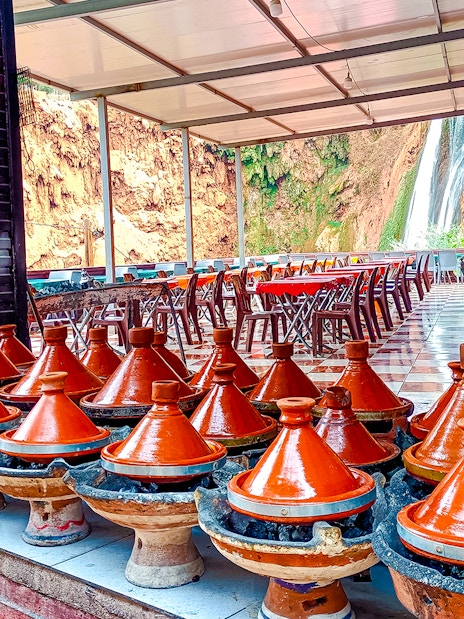 Traditional Moroccan tajines cooking in restaurant near Ouzoud Waterfalls.