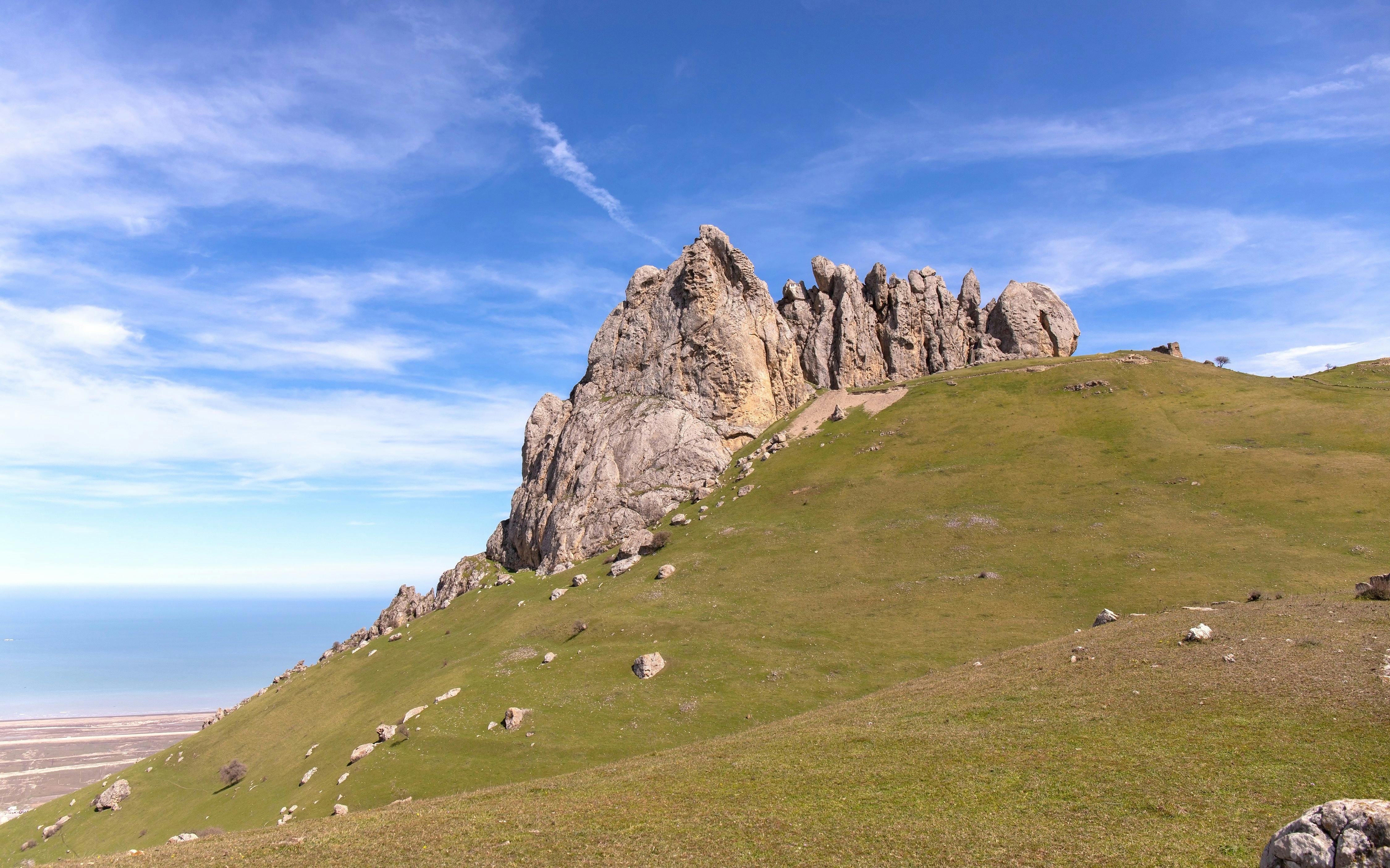 Five Fingers Mountain rock formation with grassy hillside, Baku, Azerbaijan.