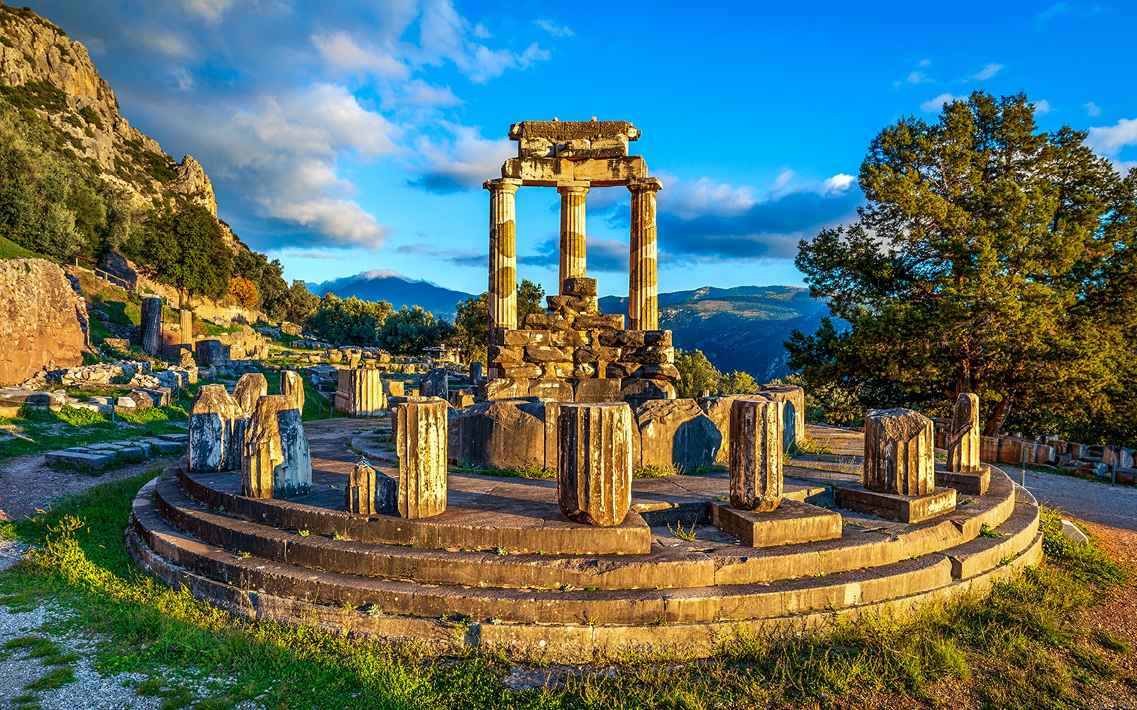Ruins of the Temple of Athena Pronaia in Delphi, Greece, with surrounding landscape.
