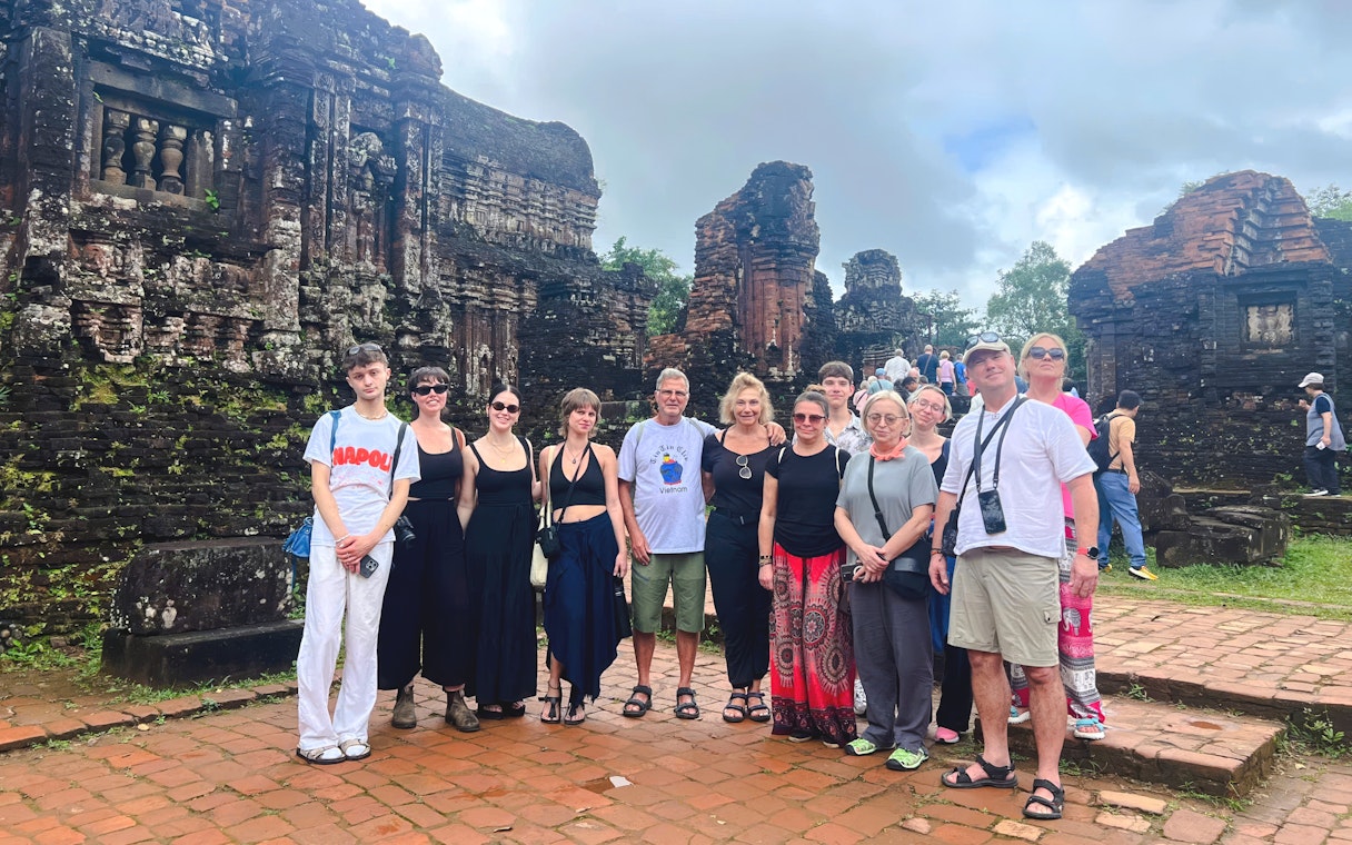Tourists exploring ancient ruins at Mỹ Sơn Sanctuary, Vietnam.