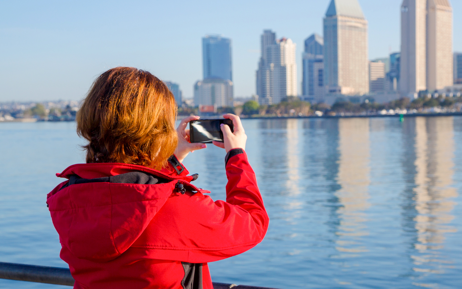 Mujer joven fotografiando con smartphone.