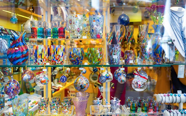 Murano glass souvenirs in Venetian shop, colorful handcrafted glassware display.