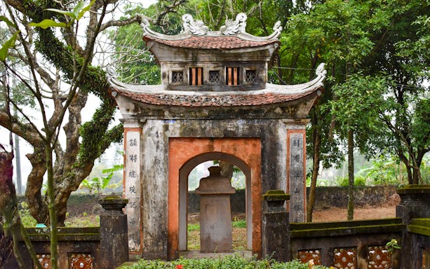 Ancient gate at Hoa Lu, surrounded by lush greenery, part of the Day Tour Hoa Lu-Tam Coc.