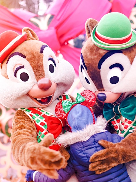 Chipmunks hugging a child at Disneyland Christmas 2025 celebration.