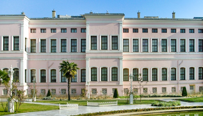 Dolmabahçe Palace Harem exterior with garden and palm tree in Istanbul.