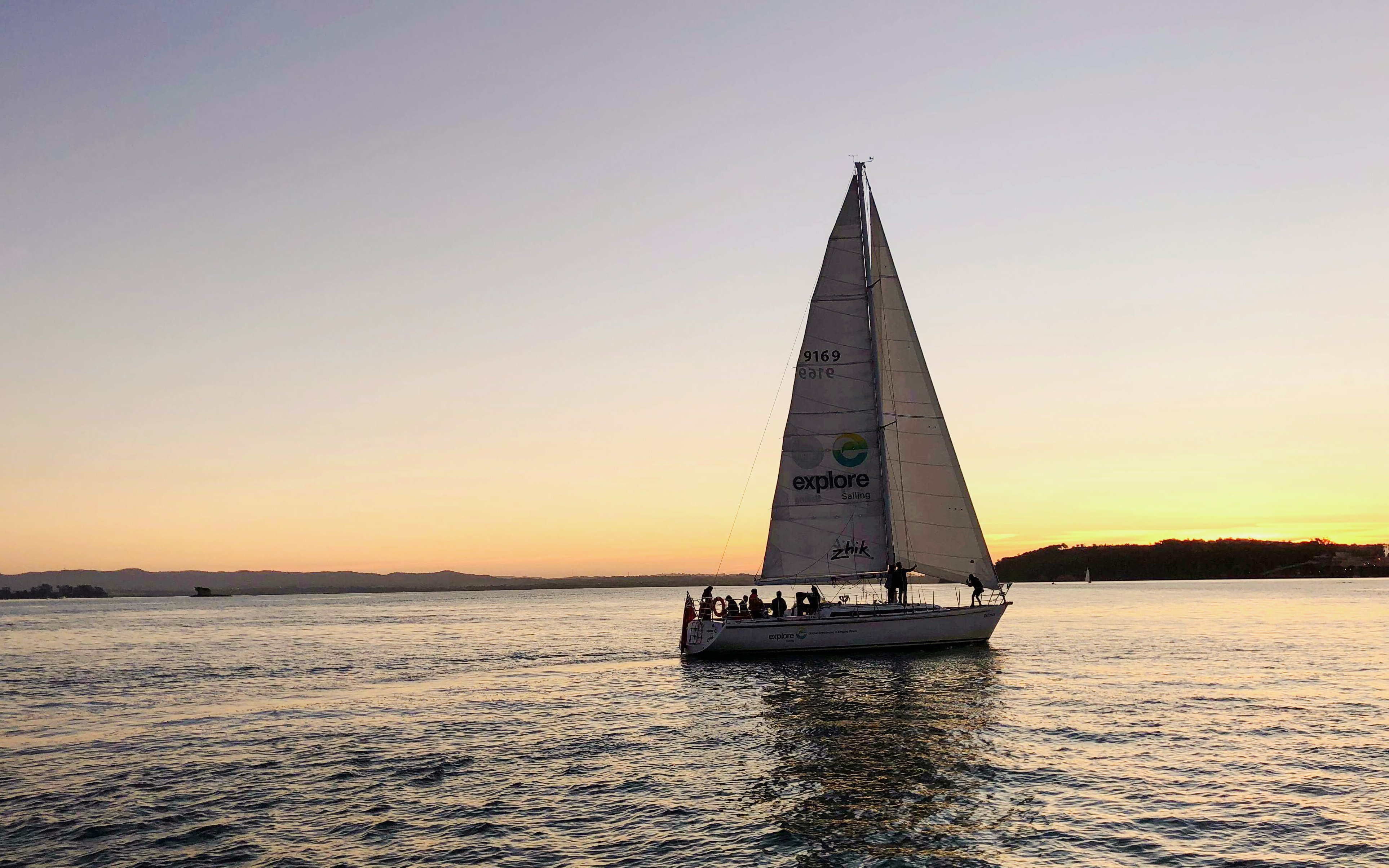 Sailboat on Auckland Harbour at sunset during a dinner cruise.
