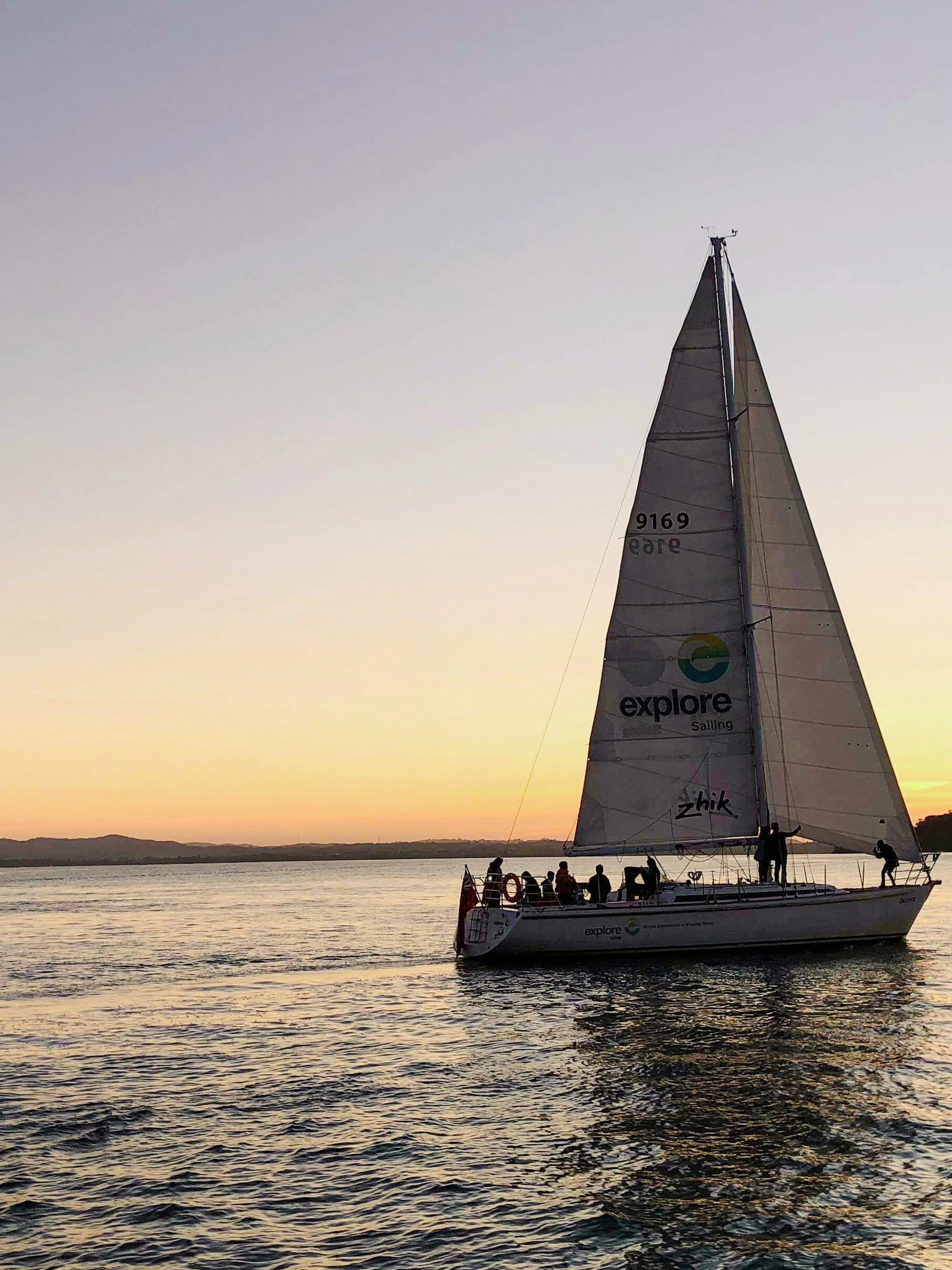 Sailboat on Auckland Harbour at sunset during a dinner cruise.