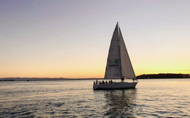 Sailboat on Auckland Harbour at sunset during a dinner cruise.
