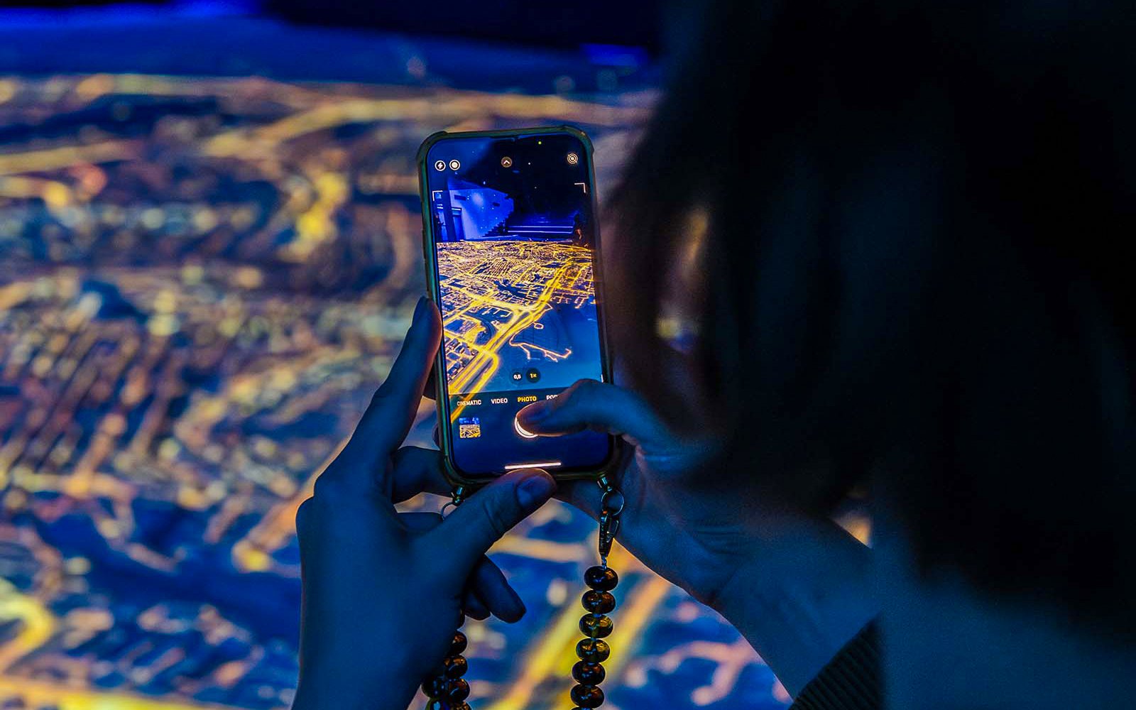 Visitor capturing digital map at Amsterdam in Motion exhibit.
