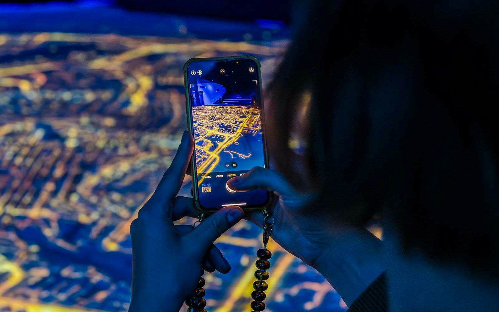 Visitor capturing digital map at Amsterdam in Motion exhibit.