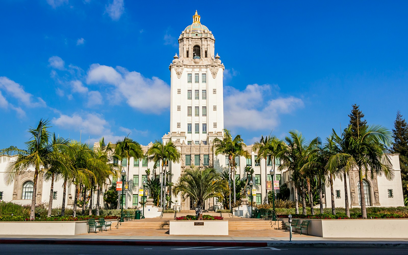 Beverly Hills City Hall with palm trees and clear blue sky.