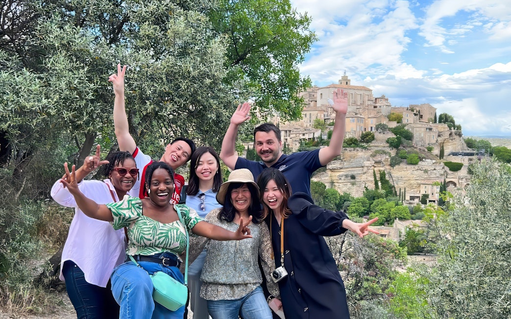 Group enjoying Lavender Full Day Tour with view of Sault village in background.