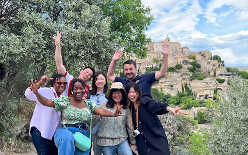 Group enjoying Lavender Full Day Tour with view of Sault village in background.