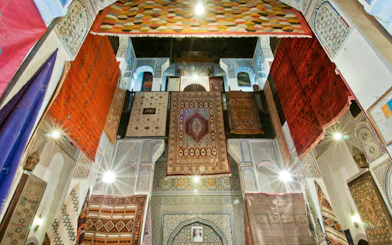 Colorful carpets hanging in a traditional Moroccan building in Fes Medina.