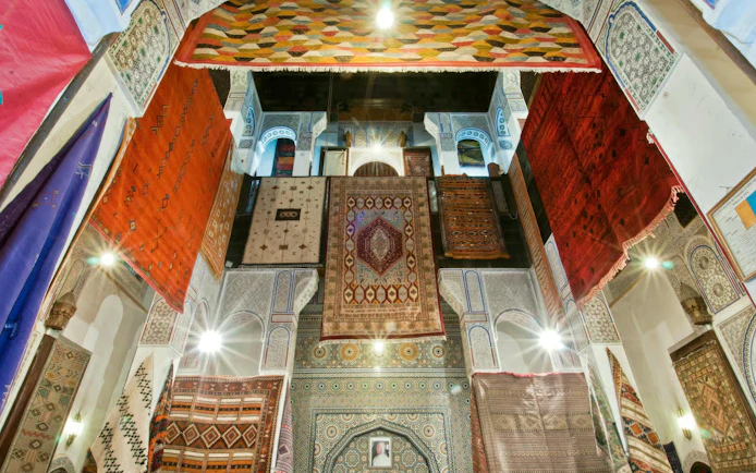 Colorful carpets hanging in a traditional Moroccan building in Fes Medina.