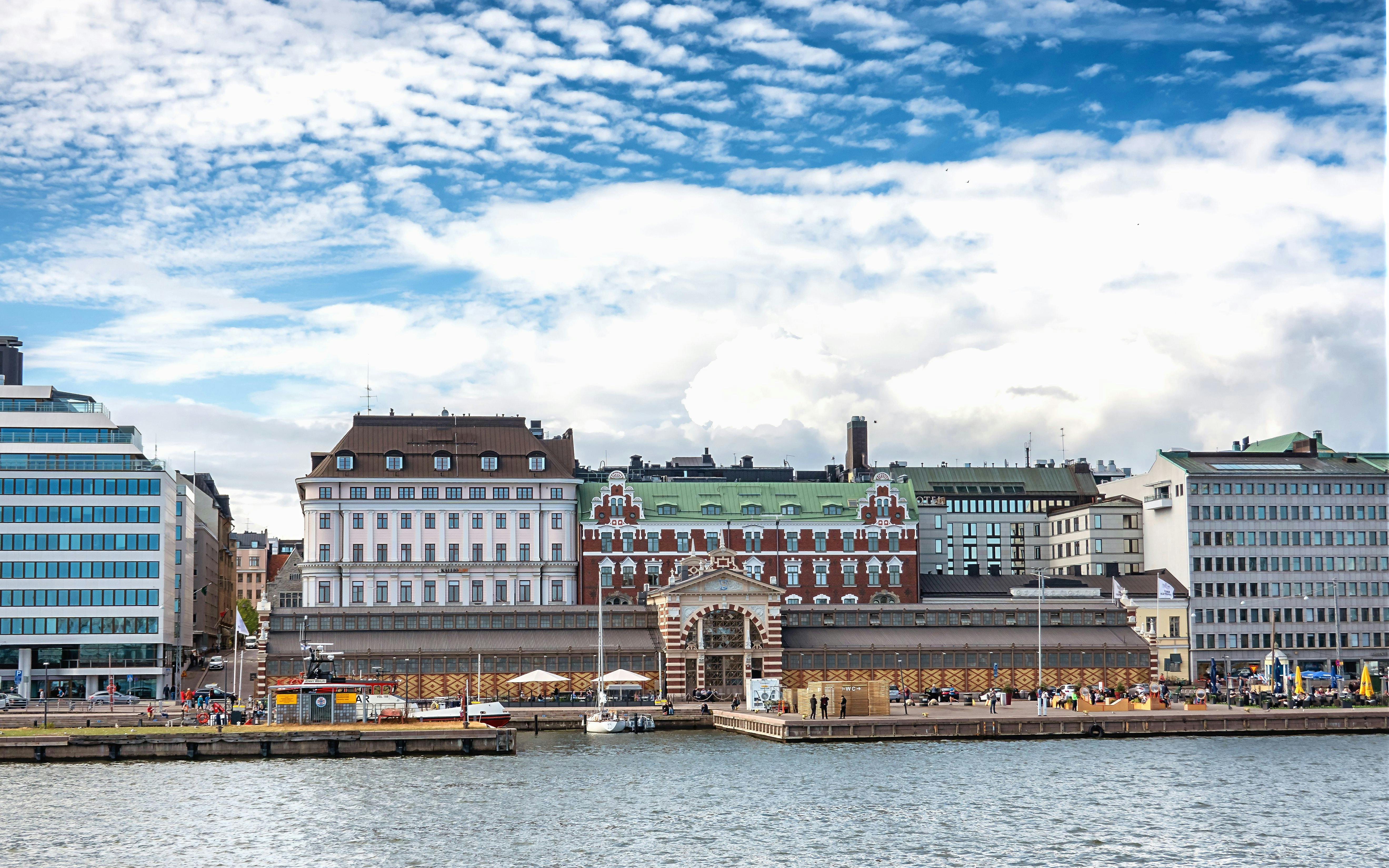 Helsinki harbor with historic market hall and waterfront buildings.