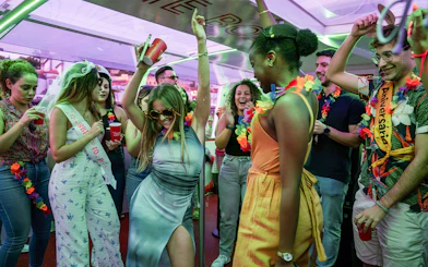 Partygoers dancing and celebrating on a Douro River cruise in Porto, Portugal.
