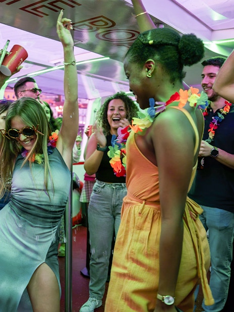 Partygoers dancing and celebrating on a Douro River cruise in Porto, Portugal.