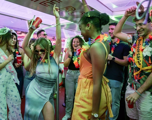 Partygoers dancing and celebrating on a Douro River cruise in Porto, Portugal.