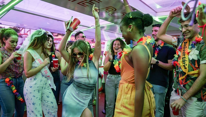 Partygoers dancing and celebrating on a Douro River cruise in Porto, Portugal.