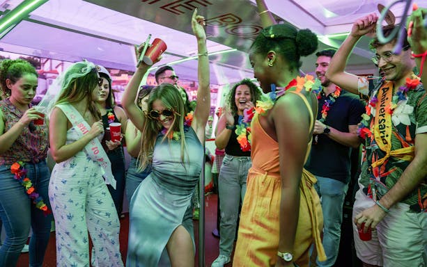 Partygoers dancing and celebrating on a Douro River cruise in Porto, Portugal.
