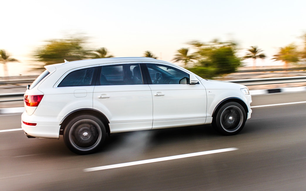 White SUV on highway for airport transfer service.