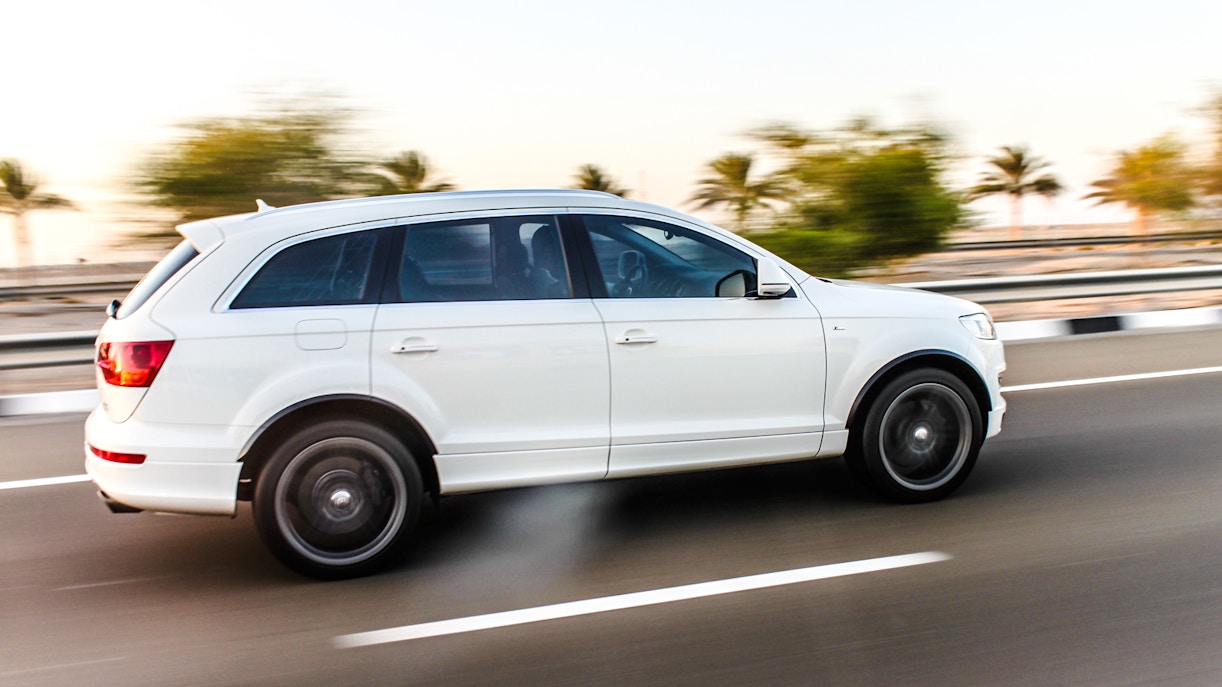 White SUV on highway for airport transfer service.