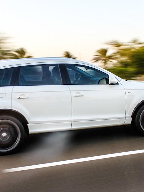 White SUV on highway for airport transfer service.