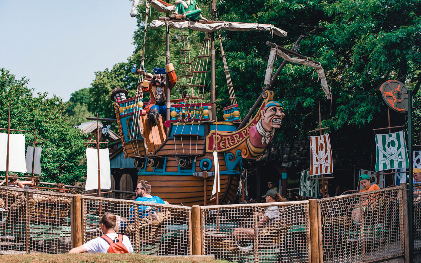 Manège Peter Pan au parc Bellewaerde, avec un bateau pirate coloré et une végétation luxuriante.