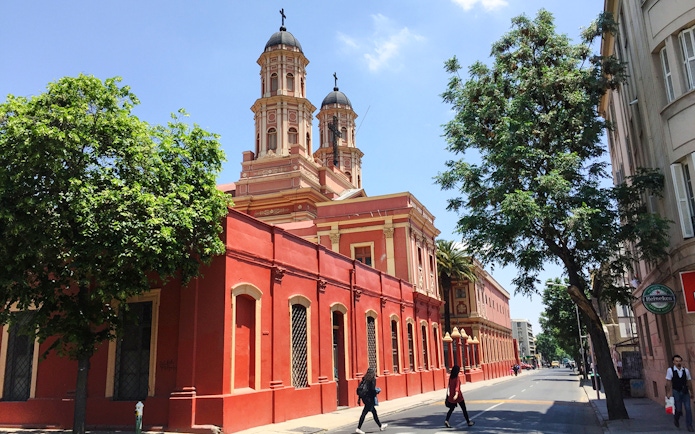 Red church building on a street in Santiago, Chile, part of the Hop-on Hop-off tour.