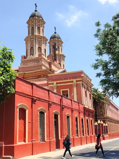 Red church building on a street in Santiago, Chile, part of the Hop-on Hop-off tour.