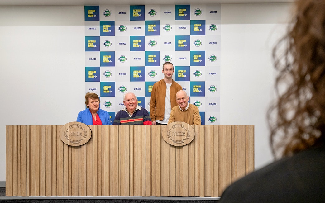 Group at MCG press conference table during Sports Lovers Day Tour.