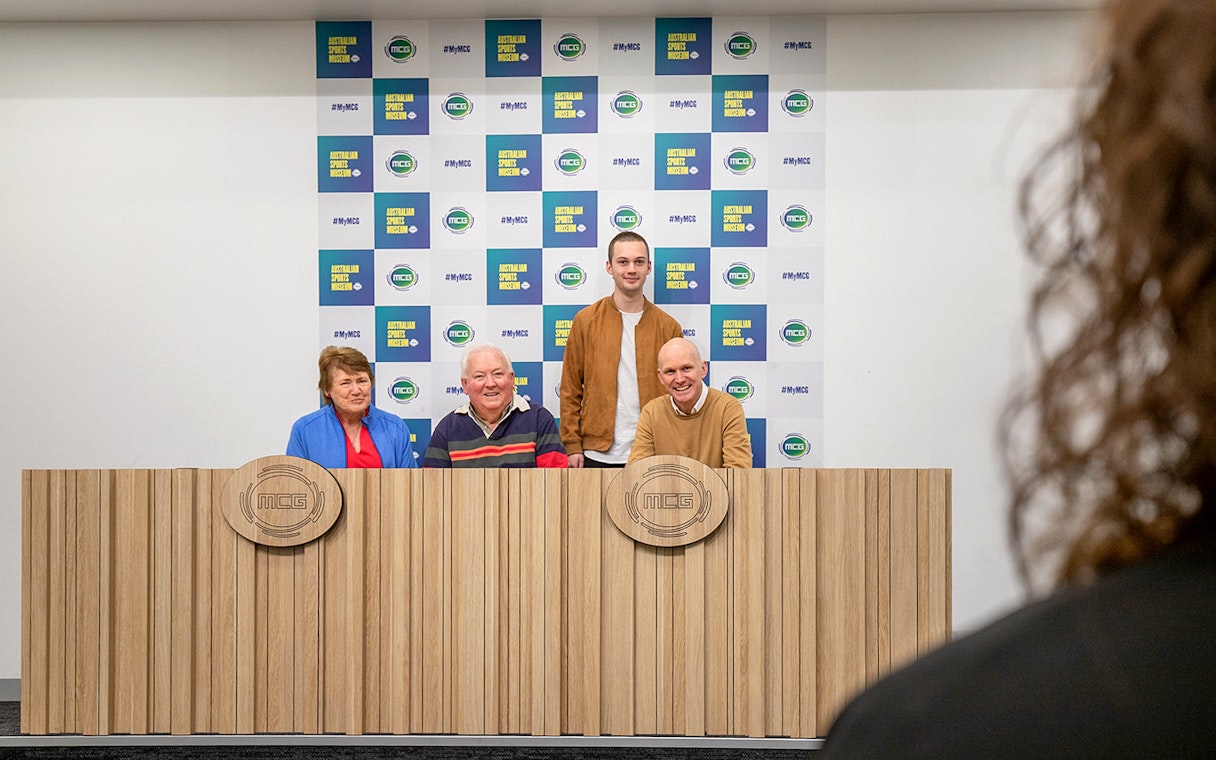 Group at MCG press conference table during Sports Lovers Day Tour.