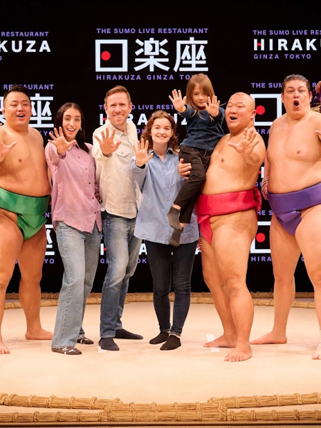 Sumo wrestlers and visitors posing at Hirakuza Ginza Tokyo Sumo Show.