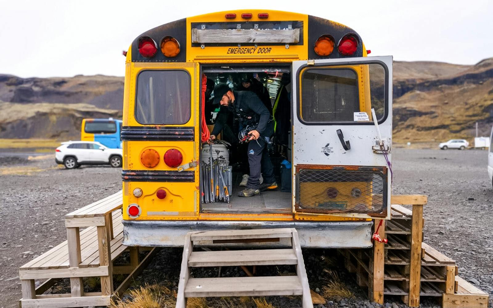 Tour guide organizing gear inside a bus for Blue Ice Glacier Hike tour.