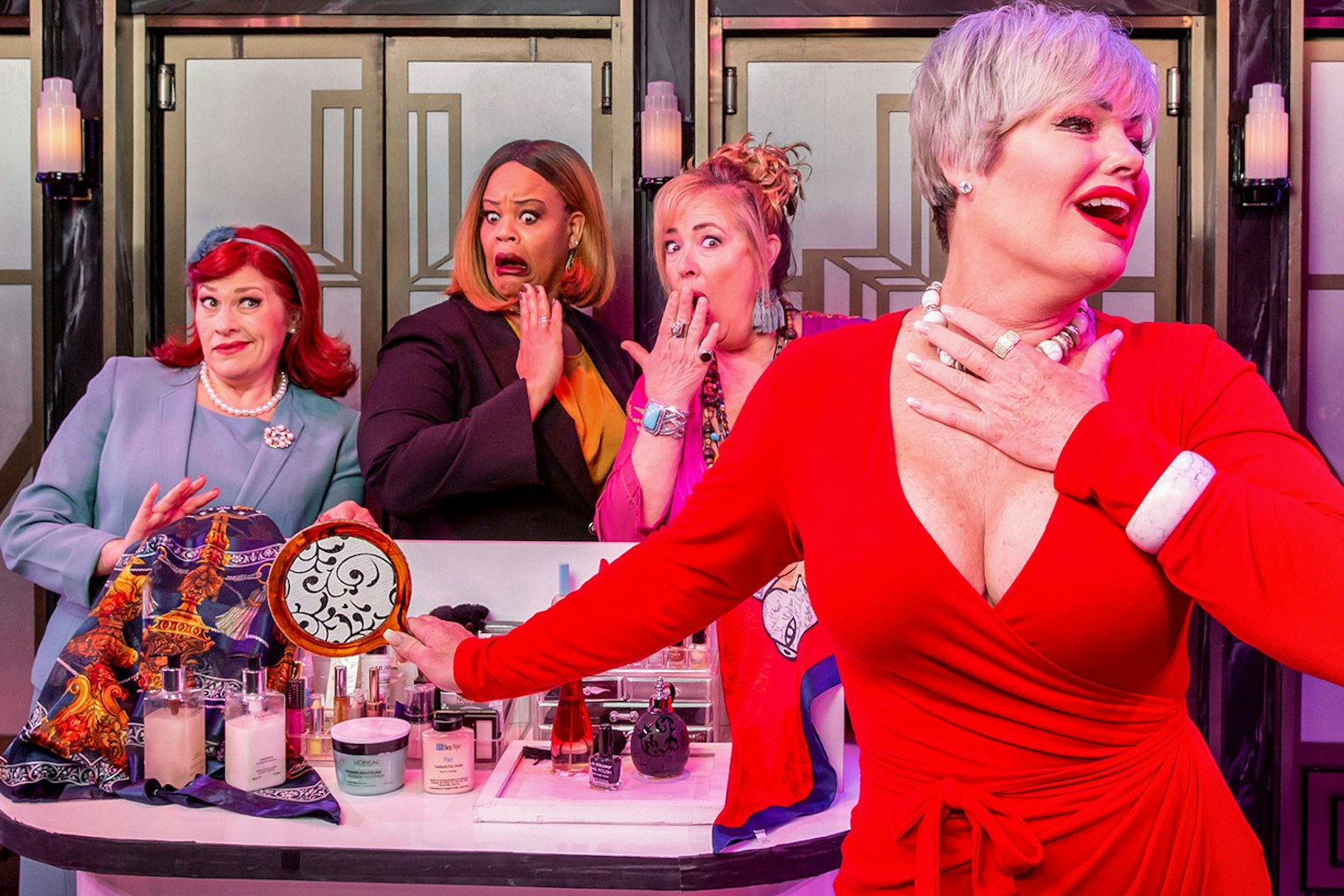 Women in colorful outfits performing a comedic scene from Menopause the Musical.