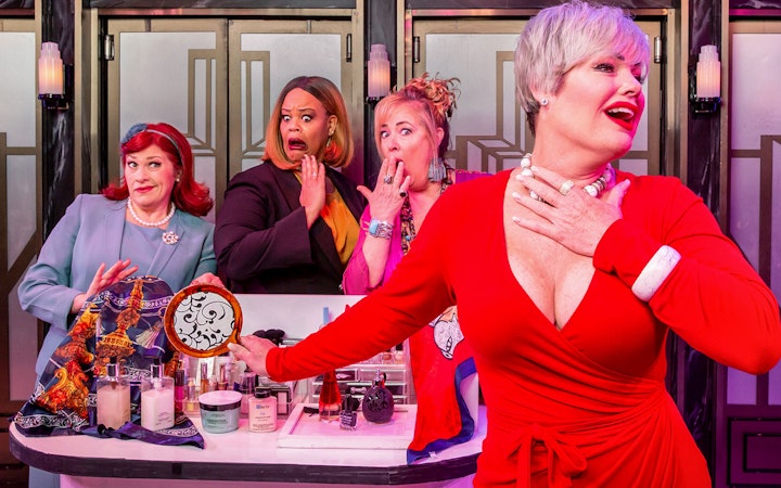 Women in colorful outfits performing a comedic scene from Menopause the Musical.