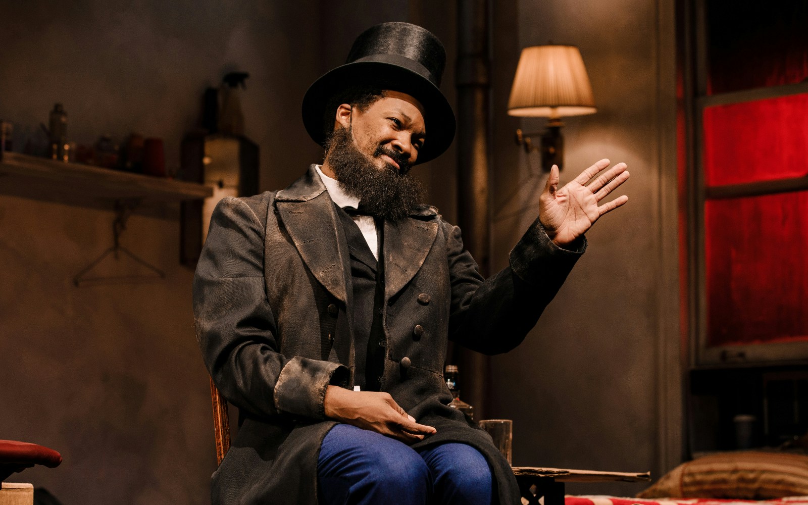 Performer in a top hat gesturing during a scene from "Topdog/Underdog" play.