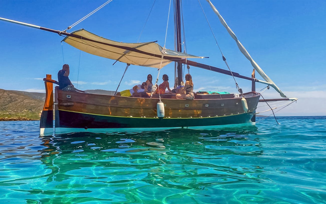 Wooden sailboat with passengers on Asinara Island excursion.