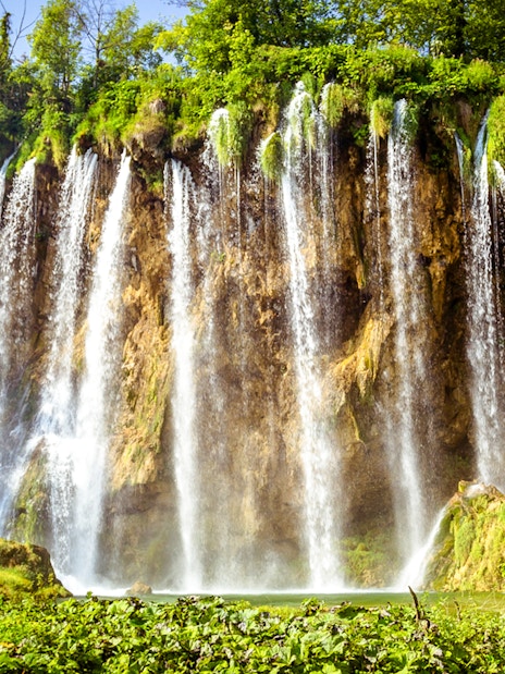 Waterfalls cascading over cliffs at Plitvice Lakes, Croatia.