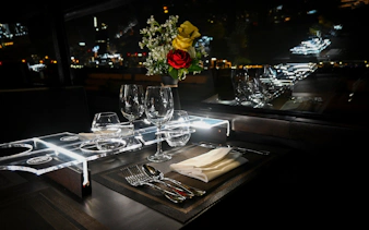 Dining setup inside Bustronome bus, Dubai, with glassware and flowers.