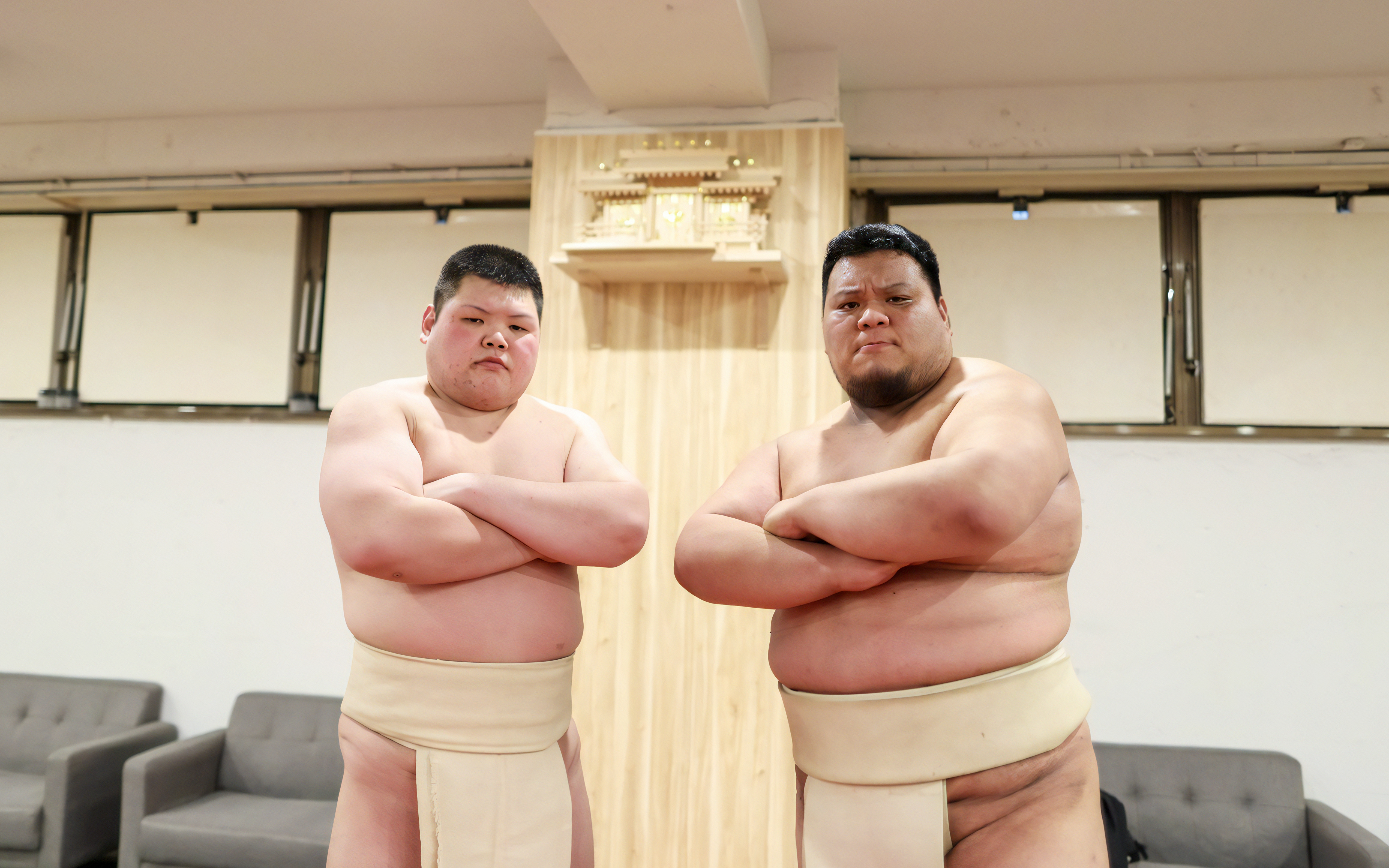 Sumo wrestlers posing after a match in a traditional Japanese setting.