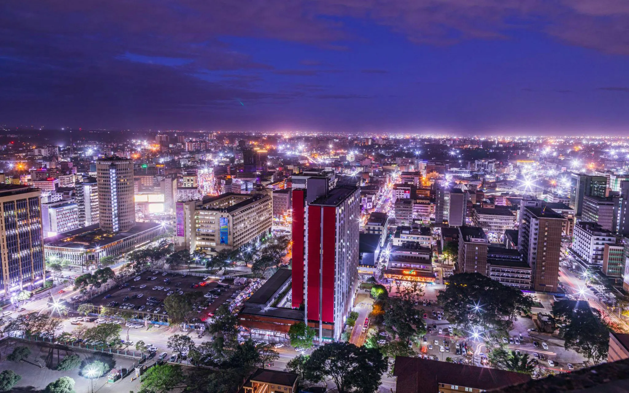 Nairobi cityscape at night with illuminated buildings and streets.