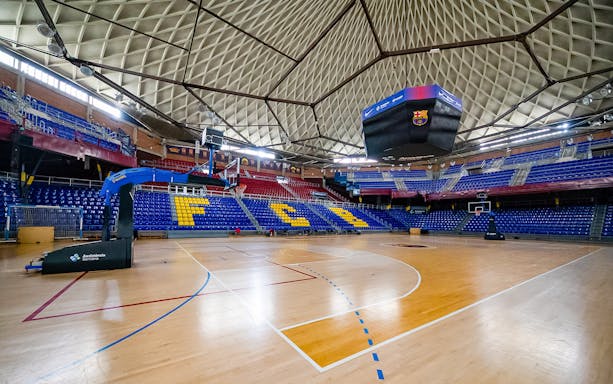 FC Barcelona Palau basketball court with empty stands and iconic ceiling.