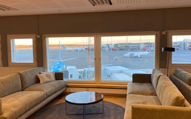Pearl Lounge seating area with airport runway view at Stockholm Arlanda Terminal 2.