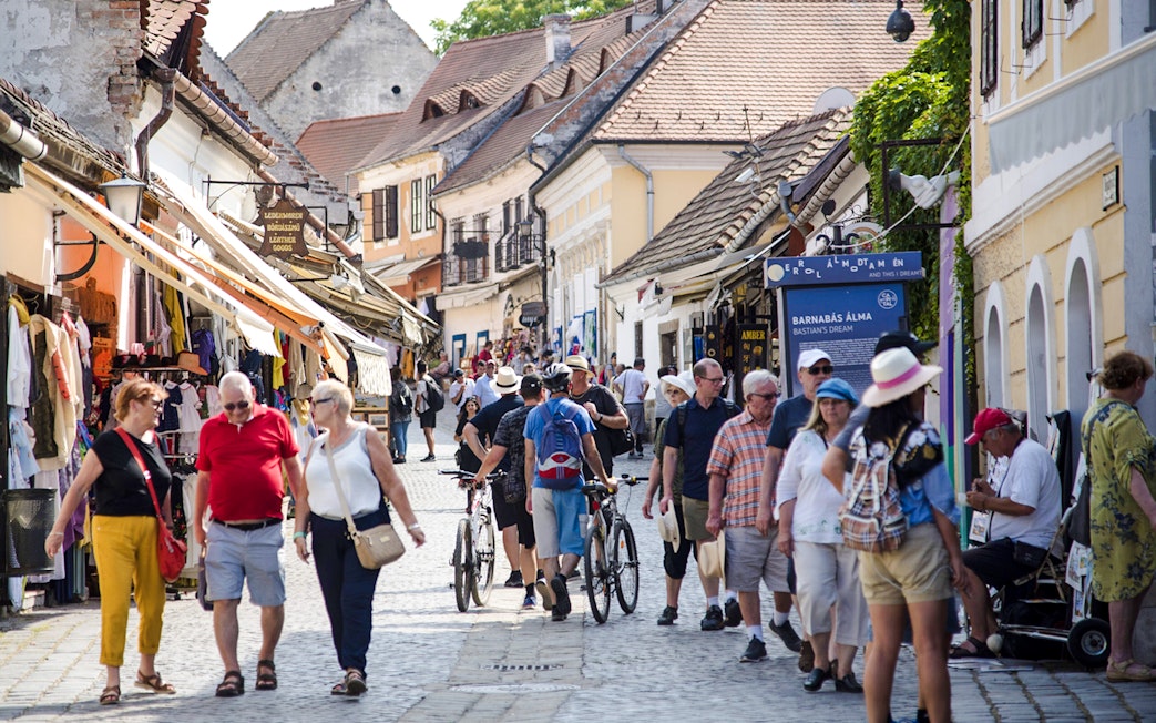Visitors walking through a bustling street in Szentendre, Hungary, lined with shops and cafes.