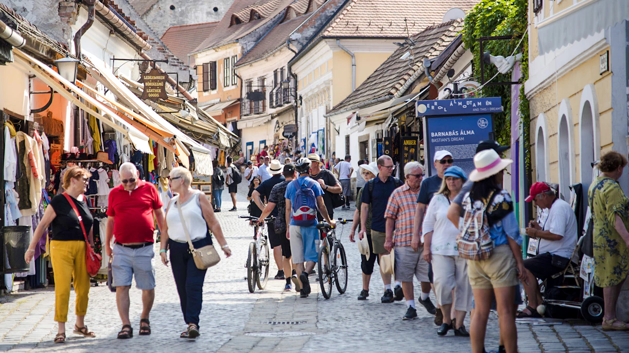 Visitors walking through a bustling street in Szentendre, Hungary, lined with shops and cafes.