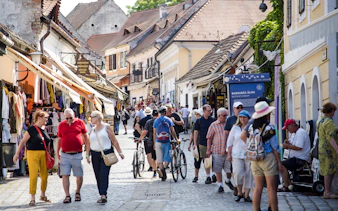 Visitors walking through a bustling street in Szentendre, Hungary, lined with shops and cafes.