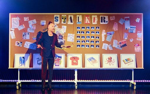 Man presenting in front of a bulletin board with "Stalker" and various photos and notes.